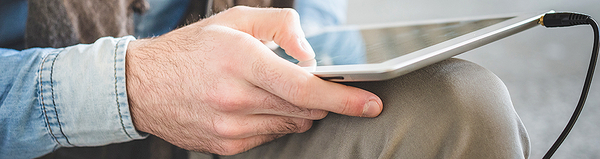 Titelbild Online-Gottesdienst: Eine Hand hält ein Tabletcomputer