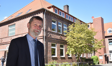Schulleiter Barkam vor seiner Schule 