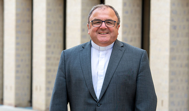 Der neue Dompropst steht vor der Diözesanbibliothek in Münster