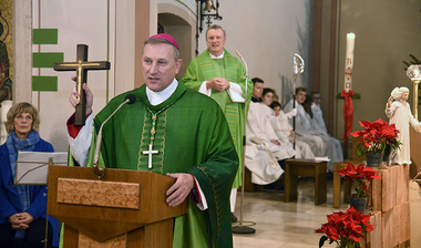 Weihbischof mit Kreuz in der Hand 