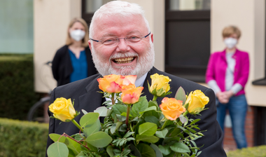 Offizialatsrat Msgr. Bernd Winter mit einem Strauß Rosen.