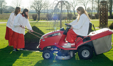 Drei Messdiener bei der Gartenarbeit 