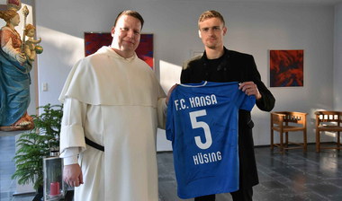 Oliver Hüsing überreicht ein Trikot