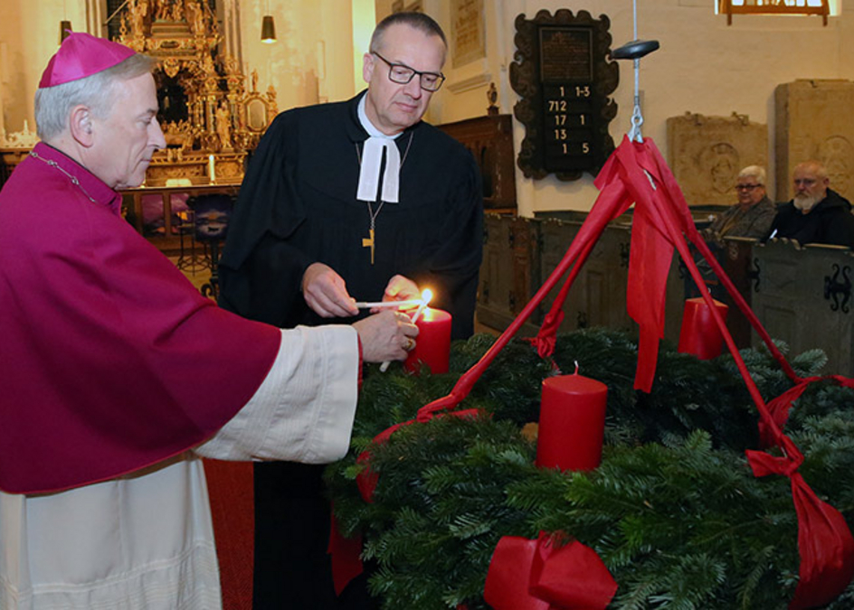 Bischöfe zünden Kerze am Adventskranz an 