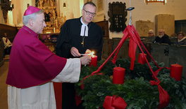 Bischöfe zünden Kerze am Adventskranz an 