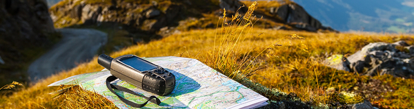 Das Foto zeigt eine Landkarte mit Bergpanorama im Hintergrund