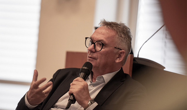 Foto: BMO/Ebert Professor Hobelsberger sitzt auf der Bühne und spricht in ein Mikrofon