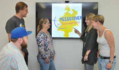 Messdinserteam schaut sich neues Loga an